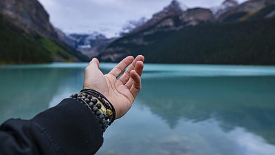 Frau hält ihre Hand segnend über einen See